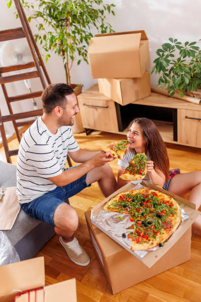 istock Couple taking a break eating pizza while moving in together 1491191252