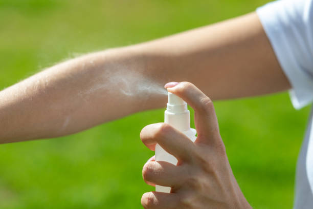 Woman spraying mosquito insect repellen Woman spraying mosquito insect repellen bug bite stock pictures, royalty-free photos & images