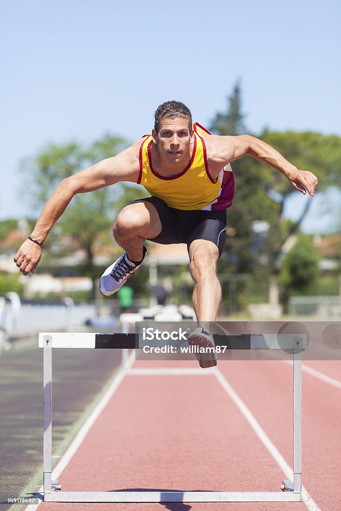 Maschio atleta durante la gara di ostacolo - Foto stock royalty-free di Adulto