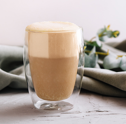 Heat-resistant double-walled glass cup filled with latte or cappuccino