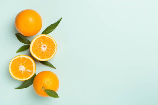 istock Flat lay with fresh oranges and leaves on color background 1491204298