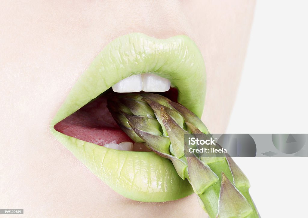 asparagus close-up of green lips eating asparagus Asparagus Stock Photo