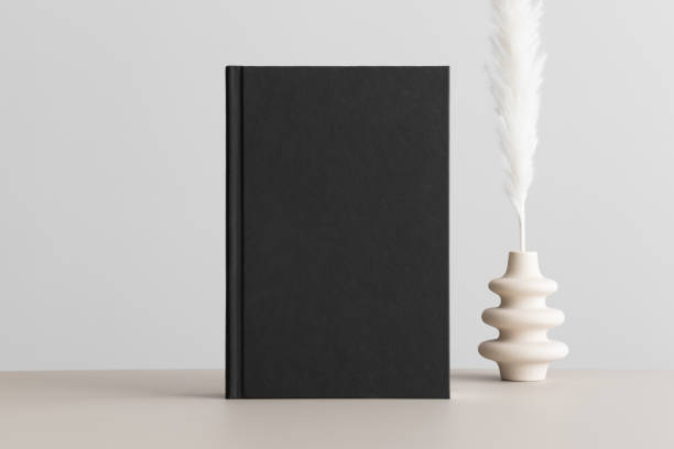 istock Black book mockup with a pampas decoration on the beige table. 1491209476