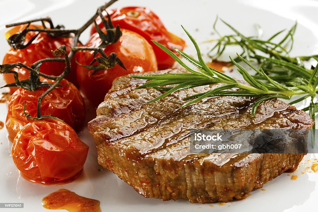 Gegrilltes beefsteak und Gebratene Tomaten - Lizenzfrei Am Spieß gebraten Stock-Foto