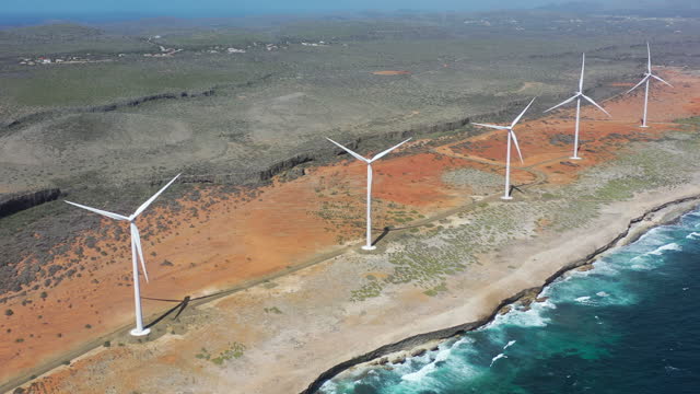 4k video,  wind turbines spinning along rocky shore,