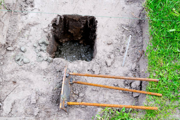 istock Iron construct with fittings preparing to hammer into ground pit or hole with cement solution, slurry, concrete mortar for building process, renovation, laying house foundation 1491211911