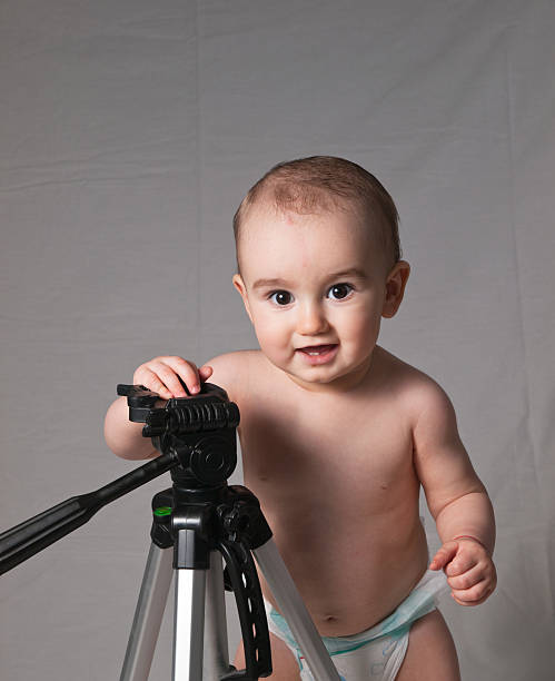 Baby Photographer posing by Tripod stock photo