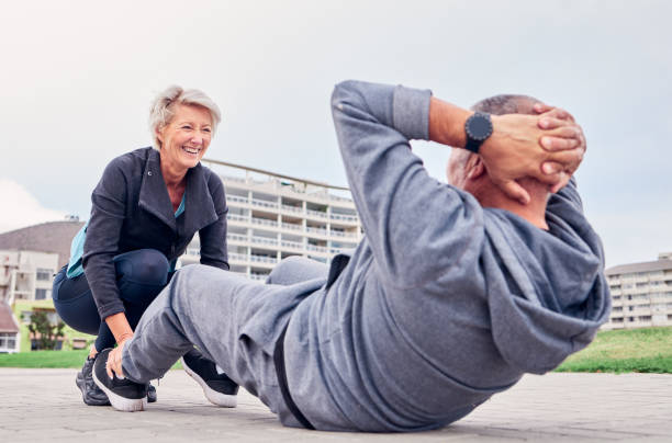 exercice, santé et redressements assis avec un couple de personnes âgées s’entraînant ensemble à l’extérieur pour un mode de vie actif d’entraînement. entraînement, fitness ou core avec un homme et une femme mûrs à l’extérieur sur la pro - core workout photos et images de collection