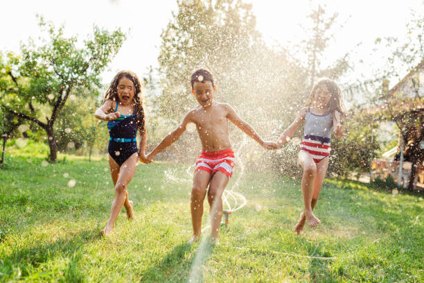 istock Children refreshing with garden sprinkler 1491214926