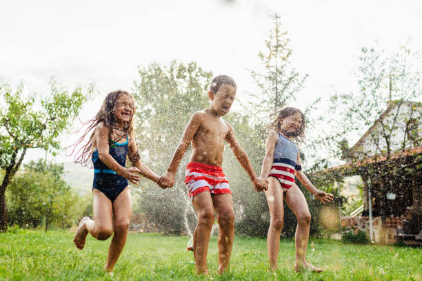 istock Children refreshing with garden sprinkler 1491215005