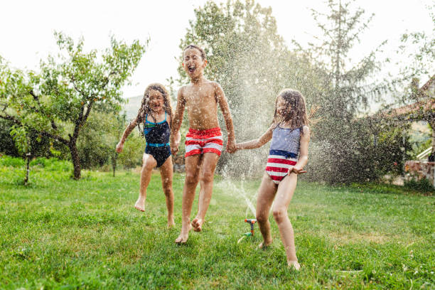 istock Children refreshing with garden sprinkler 1491215061