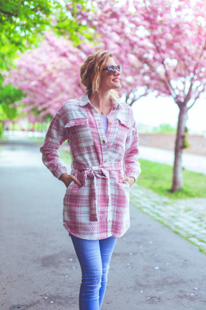 istock Young positive woman walking in park during Sakura 1491217217