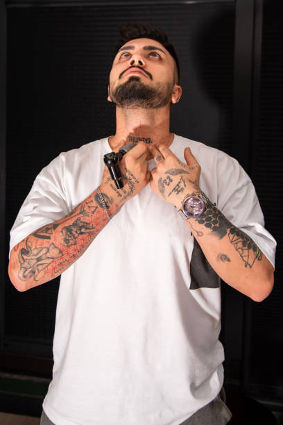istock Professional tattooer doing tattoo yourself using tattoo machine in studio 1491220957