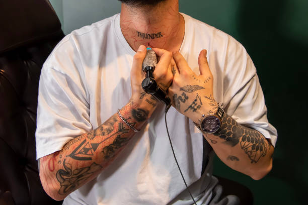 istock Professional tattooer doing tattoo yourself using tattoo machine in studio 1491220959