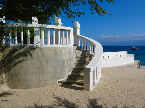 Stairway to the sea. Semicircular white stone staircase with steps on the seashore.