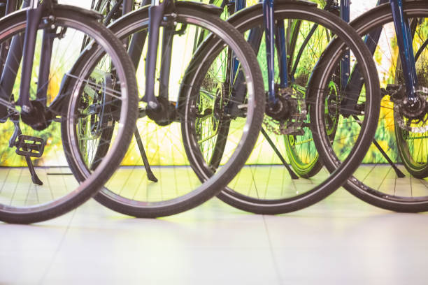 Bikes standing in a row in bicycle shop. Focus on wheels.