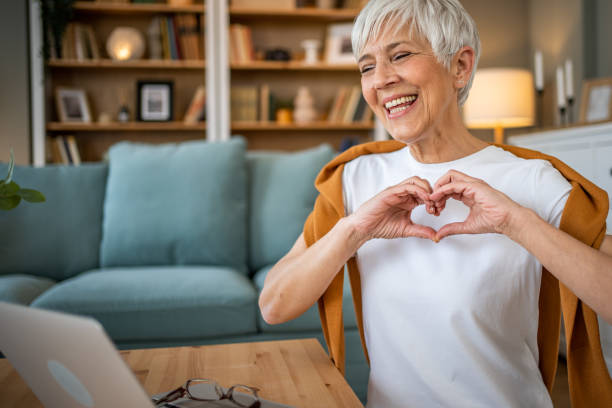 istock Happy elderly woman making a heart sign with her hands 1491228863
