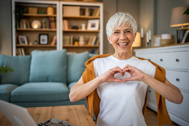 istock Happy elderly woman making a heart sign with her hands 1491228883