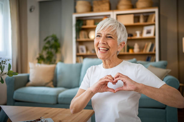 istock Happy elderly woman making a heart sign with her hands 1491228923