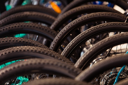 Bikes standing in a row in bicycle shop. Close up of tires.
