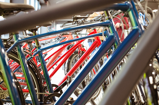 Bikes standing in a row in bicycle shop. Close up of frames.