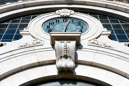 Lisbon, Portugal - April 25, 2023: Close up low-angle view of the clock face and surroundings of the Time Out Market. No people are on the scene.