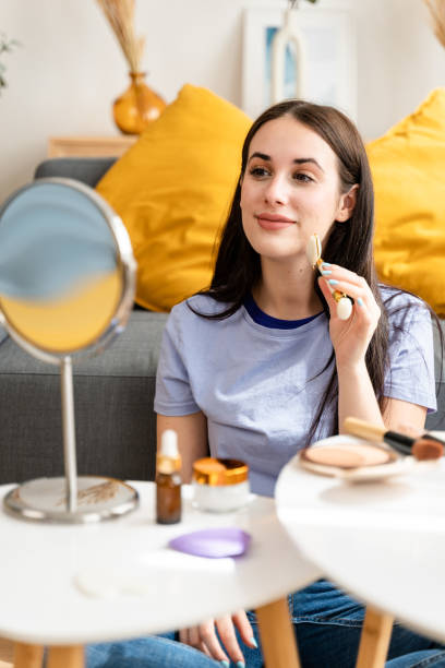 mujer masajeando su cara con un rodillo de cuarzo. - quartz caucasian one person energy fotografías e imágenes de stock