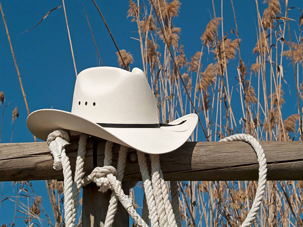 White cowboy hat and rope in a country fence
