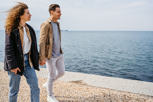 Young couple walking on the quayside in Thessaloniki, Greece.