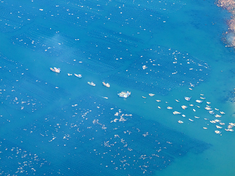 Aerial photograph of fish farms and fishing boats at sea