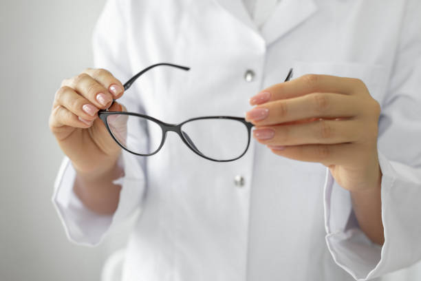 istock Female optician hands giving new glasses to customer for testing 1491240338