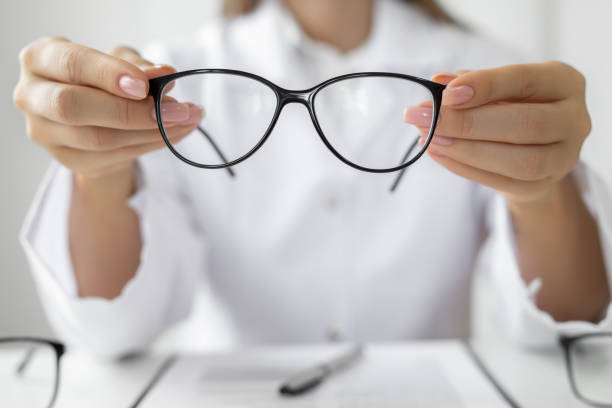istock Female optician hands giving new glasses to customer for testing 1491240476