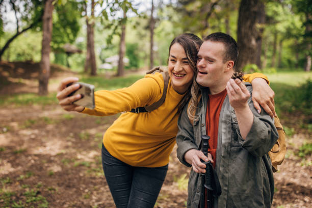 istock Two friends taking picture with mobile phone with pinecone they found in the forest while hiking 1491246121