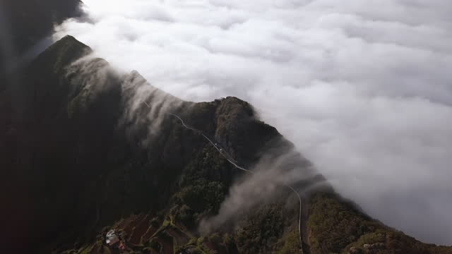 Time lapse aerial view of clouds running over mountain road in Anaga mountain range, Tenerife, Canary islands, Spain.