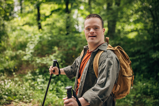 Young man with Down syndrome hiking in the forest