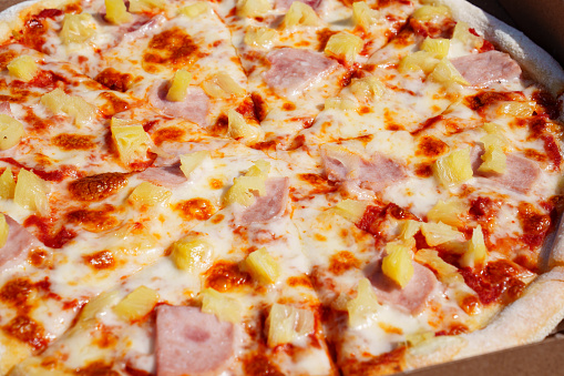 Pizza with pineapple and ham is a popular type of pizza known as Hawaiian pizza. It features a tomato sauce base, mozzarella cheese, ham, and pineapple as the main toppings.