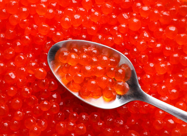 istock Red caviar in a spoon, background. Top view 1491257265