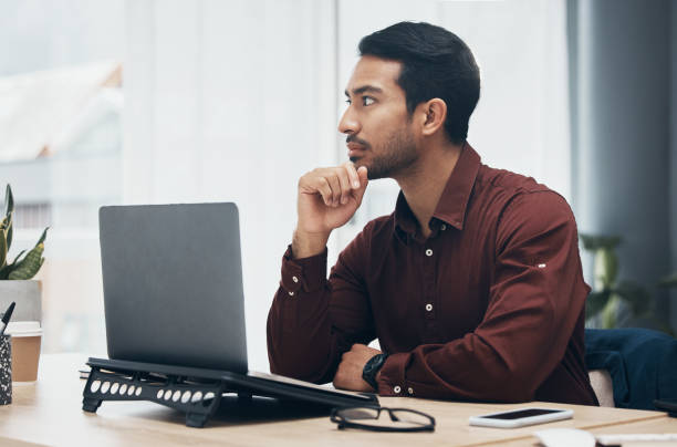 istock Laptop, thinking and business man in office contemplating, planning or decision making. Idea, thoughts and pensive professional, problem solving or looking for solution to work project in workplace. 1491258899