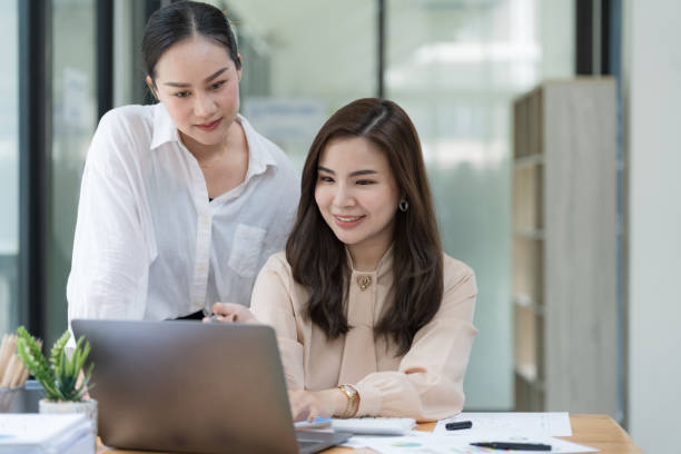 istock Two Young Asian businesswomen discuss with new startup project Idea presentation and analyze planning and financial statistics and investment market at an office. 1491259808