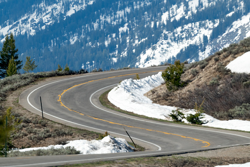 Highway curves through the Grand Teton National Park in the Yellowstone Ecosystem of Wyoming in western USA of North America.  Nearest cities are Denver, Colorado, Salt Lake City, Moose, Moran, Jackson, Wyoming, Gardiner, Cooke City, Bozeman and Billings, Montana.
