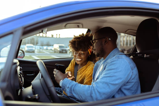 istock Cheerful African American couple using smart phone in car 1491270063