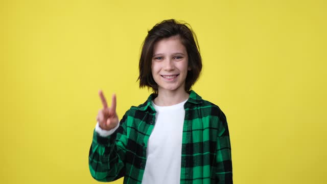 Happy Caucasian boy showing victory sign
