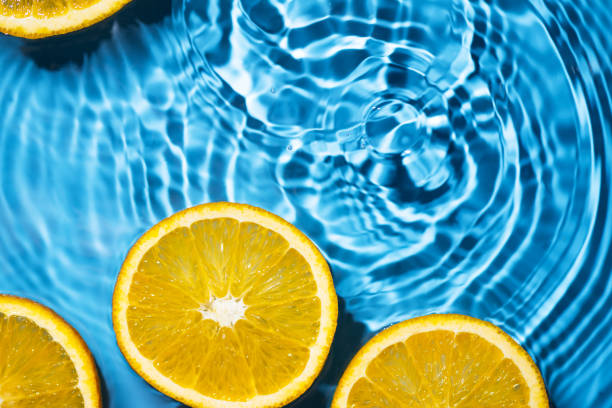 istock Creative summer background with orange fruit slices in swimming pool water. 1491273389