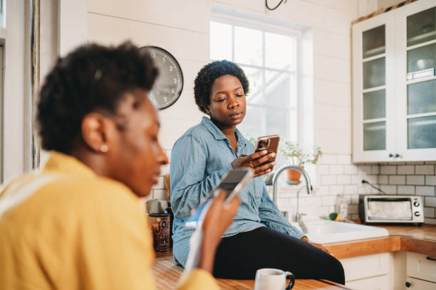 istock Two friends are looking at smart phones at home 1491274149
