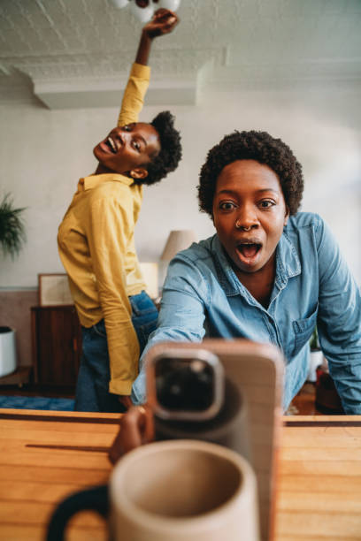Two friends are dancing together at home while they are streaming with a smart phone