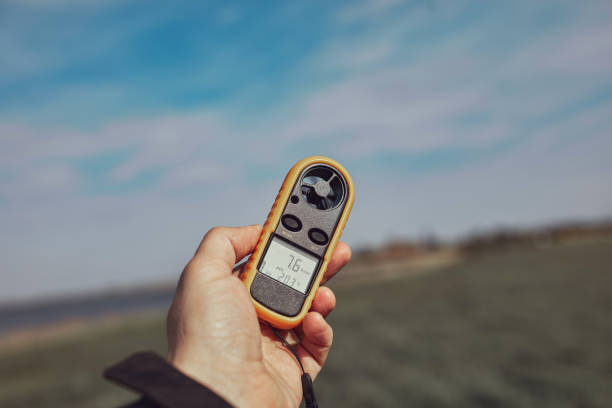 istock Person holding modern digital anemometer outdoors for measuring wind speed, temperature, humidity and other atmospheric effects. 1491274859