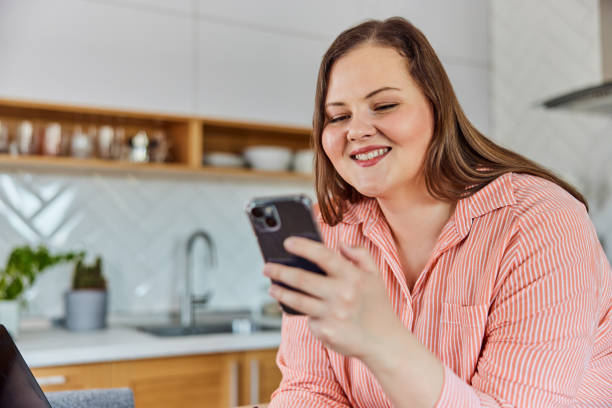 istock A smiling businesswoman working from home, using a mobile phone and laptop. 1491276395