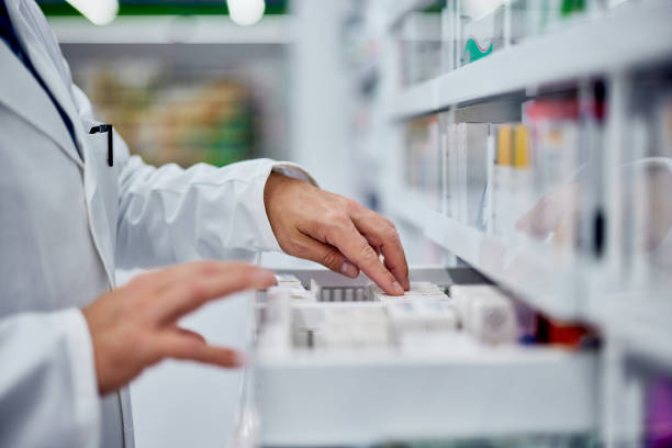 Side view of a male hands, searching for something from the drawer, working as a pharmacist. Male pharmacist choosing a medicine from the drawer, side view. drugs stock pictures, royalty-free photos & images