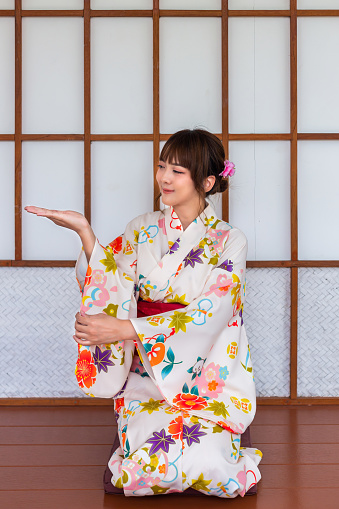 Young woman wearing Japanese traditional kimono in Japanese style wooden house
