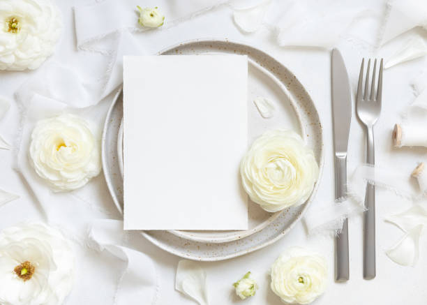istock Wedding table setting with card near cream roses and white silk ribbons top view, mockup 1491277406